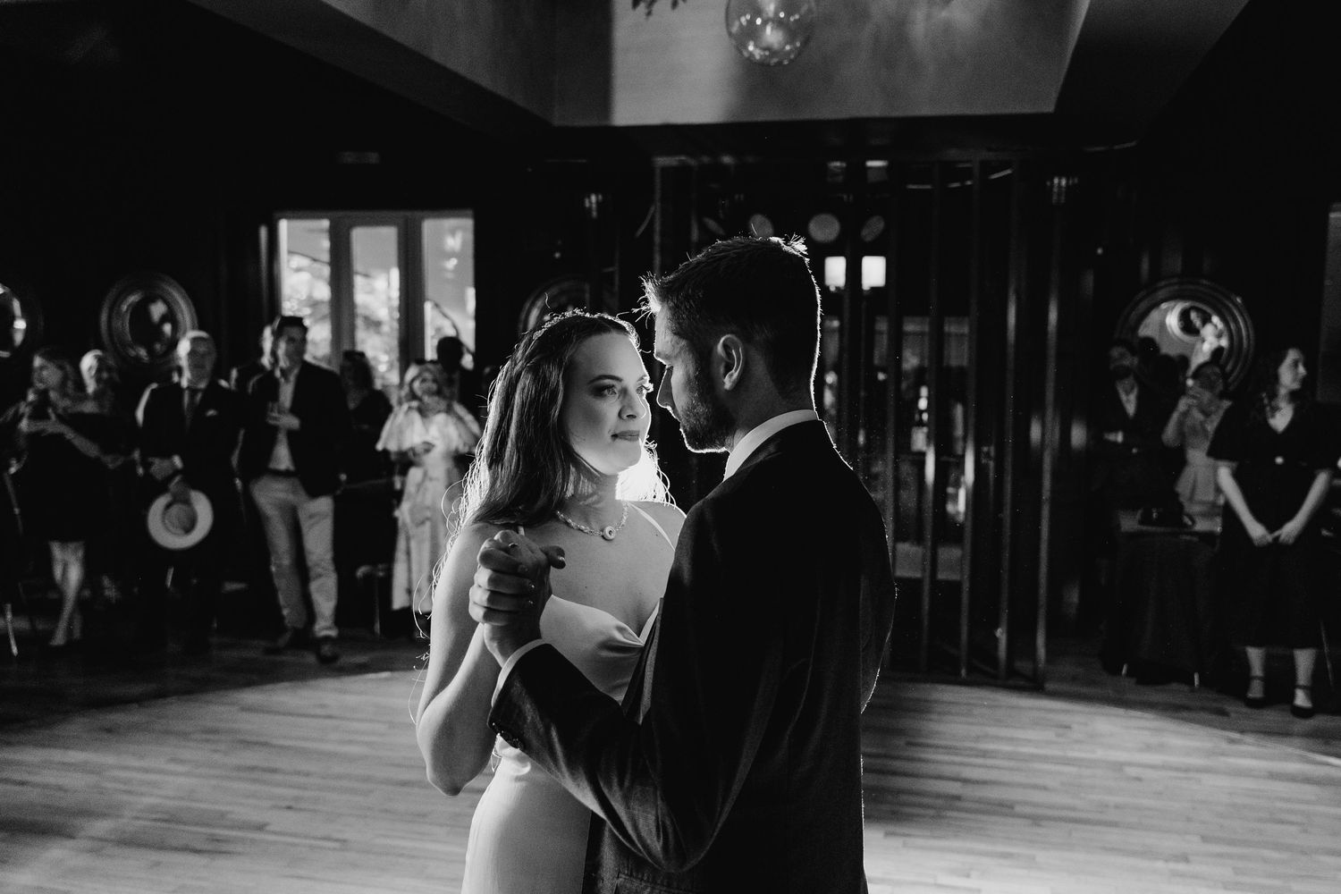 Poulaphouca Wedding photographer wicklow Romantic first dance between newlyweds on a dimly lit wooden dance floor.