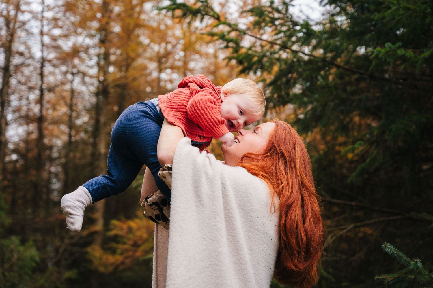 Family Photographer Dublin Ireland Autumn family portrait session among tall pine trees with warm lighting and natural poses.