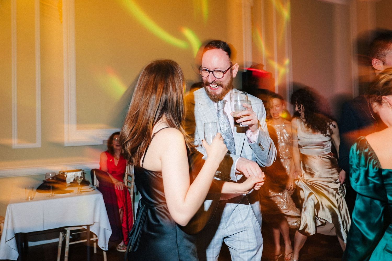 Wedding reception dance floor filled with guests enjoying the celebration under ambient lighting. Stephens green club dublin Wedding photogr