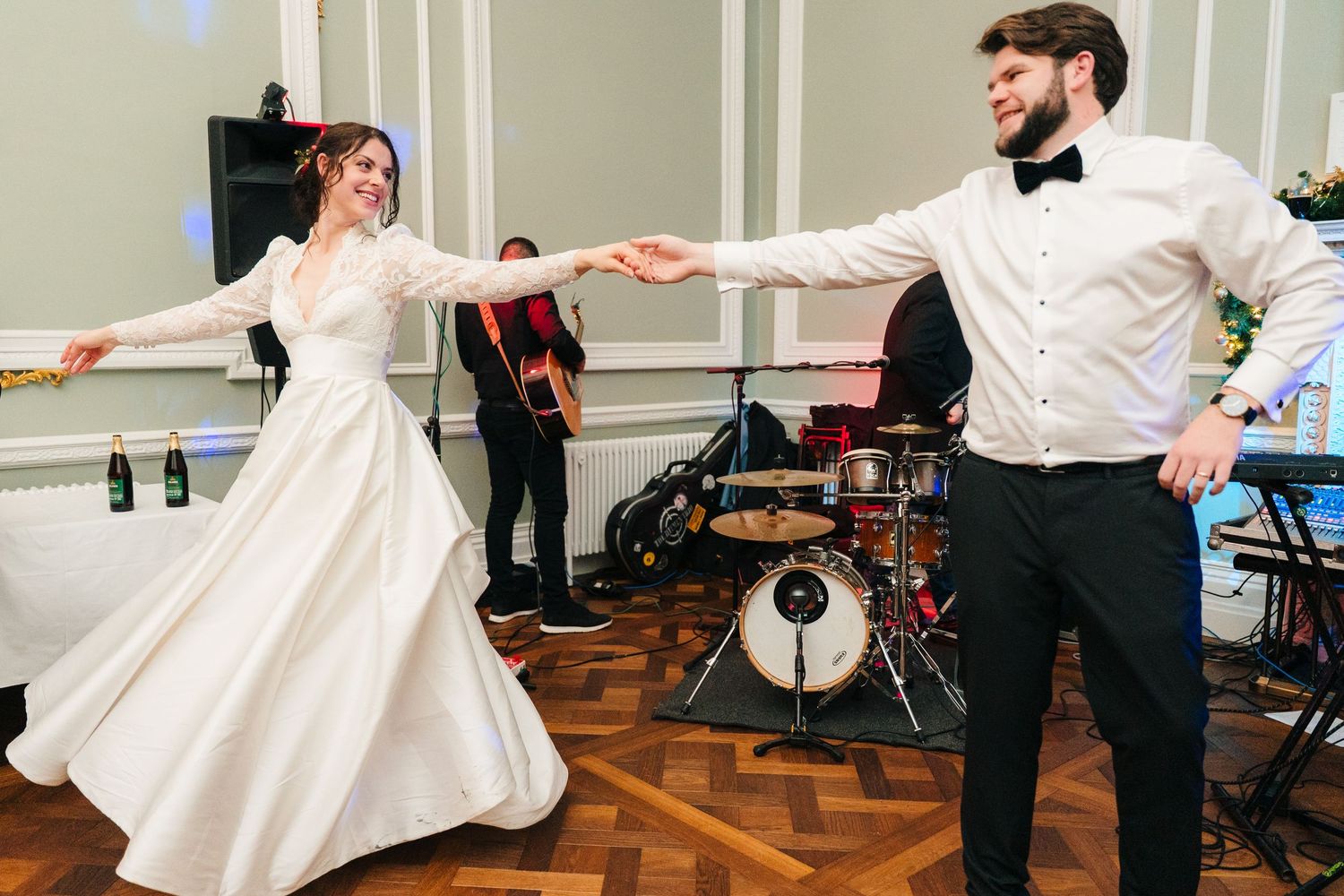 Couple dancing energetically in formal attire with band setup in background. Stephens green club dublin Wedding photographer