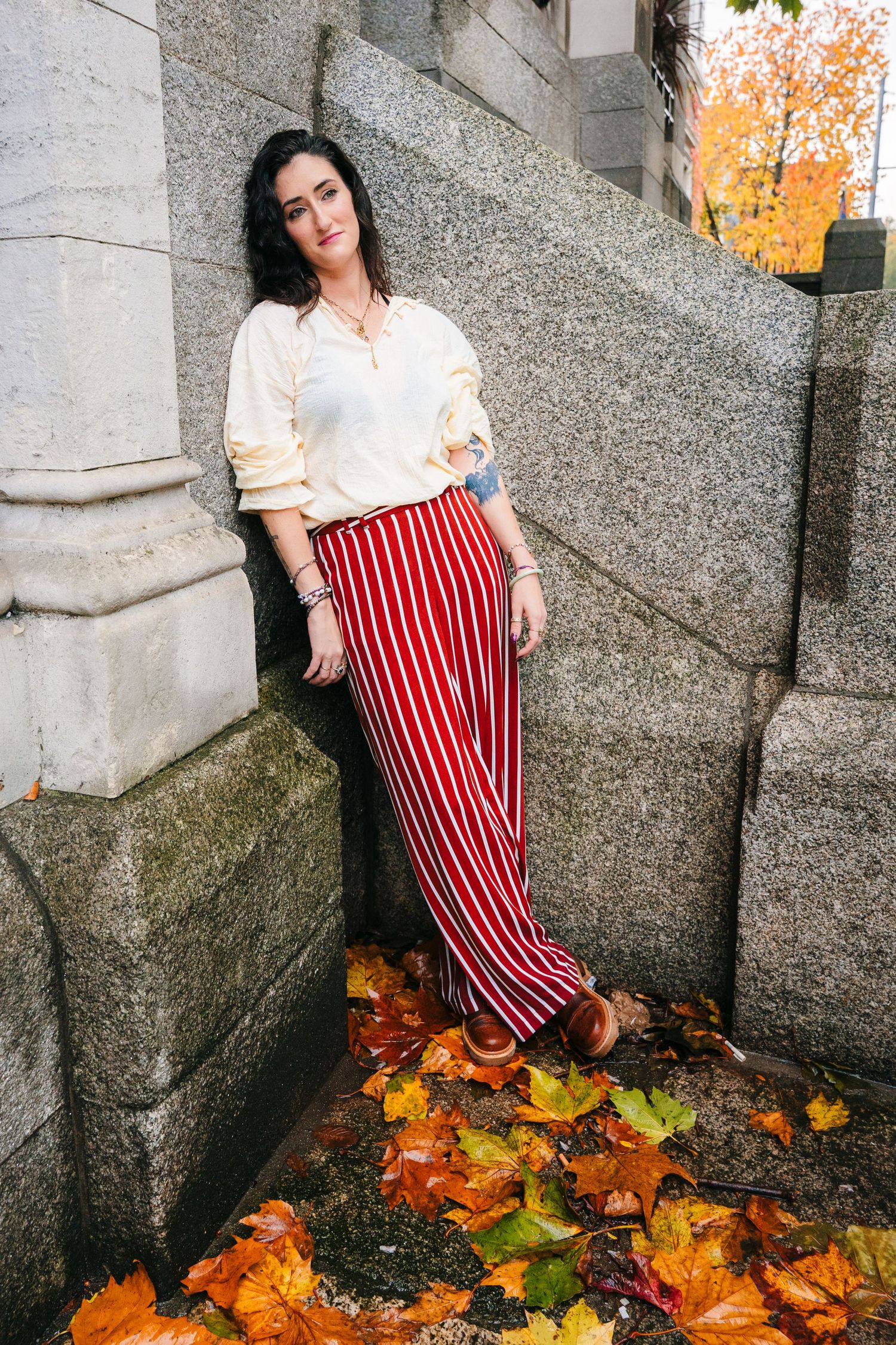 Red and white striped pants against autumn leaves on concrete ground create seasonal contrast. professional headshots dublin photographer