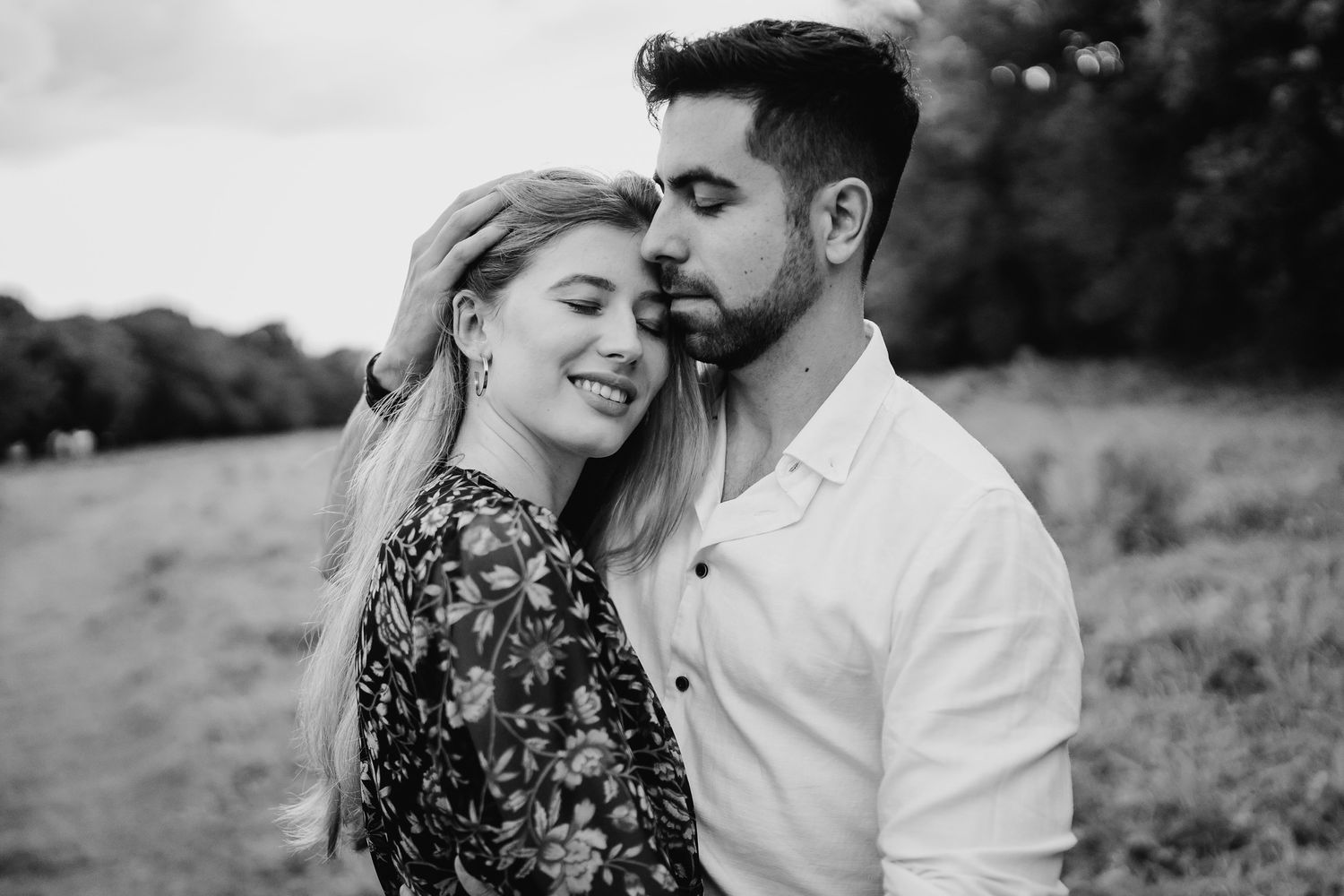 A romantic couple shares tender moments in a meadow during an intimate black and white photoshoot. PHOTOGRAPHER Dublin ireland