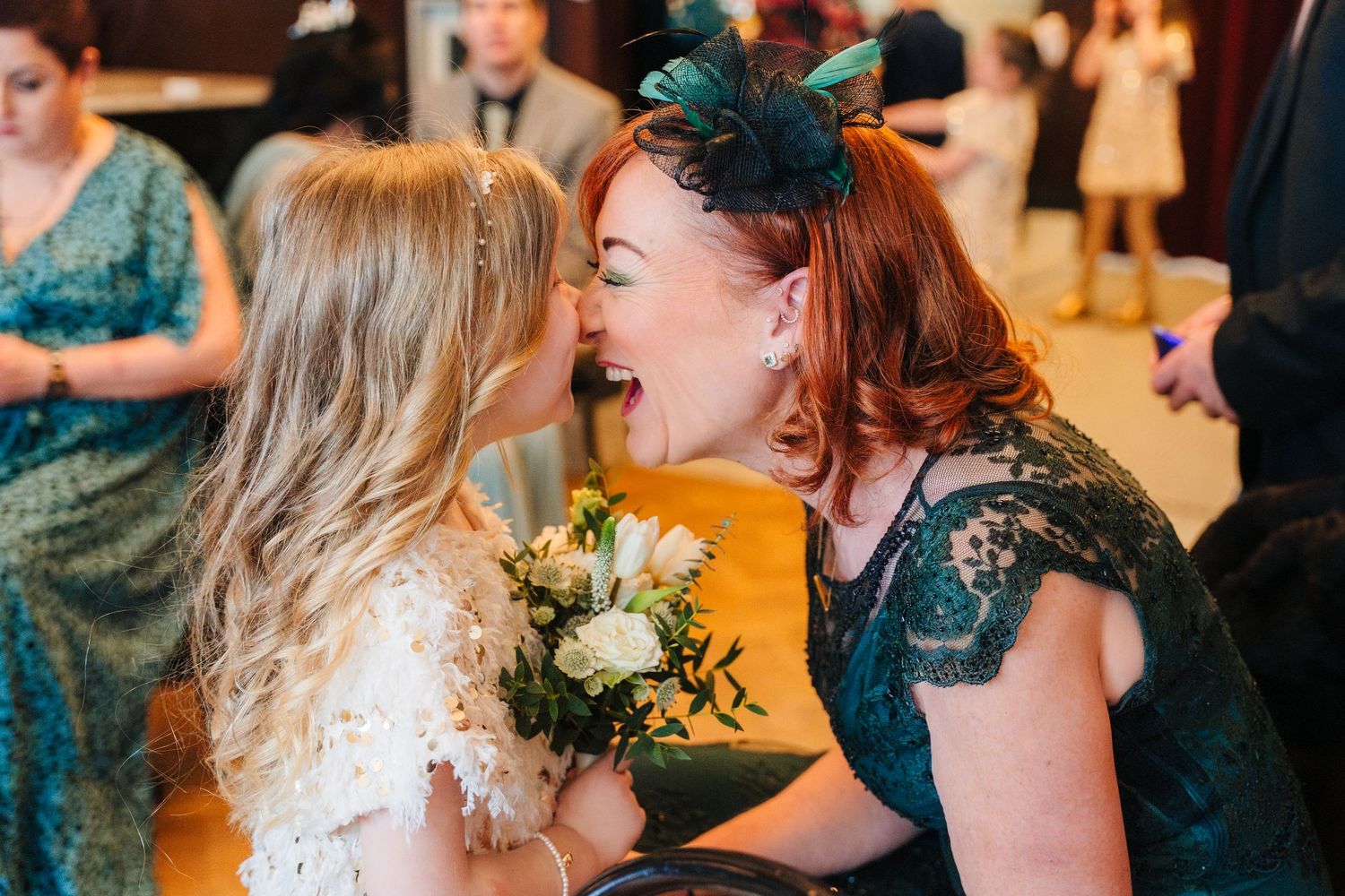Intimate wedding reception moment with guests sharing laughter and conversation in a warmly lit indoor venue. Dublin wedding photogrAPher Be
