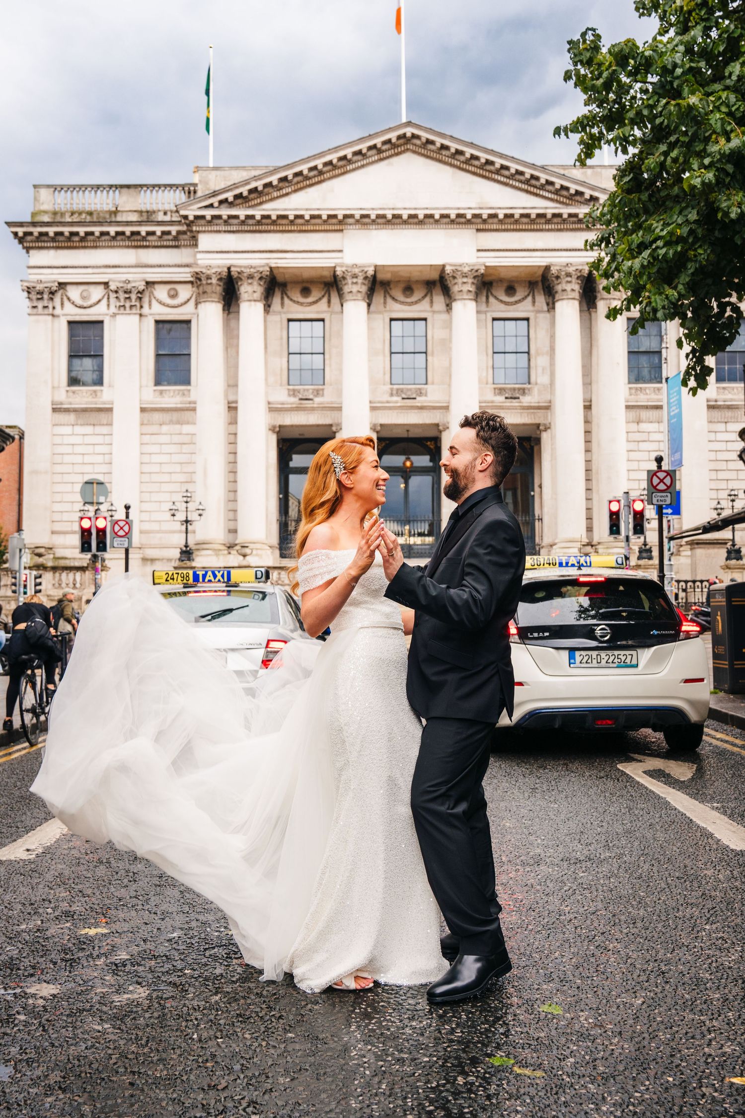 Wedding couple dances outside a grand neoclassical building with white columns.  city hall dublin wedding photos