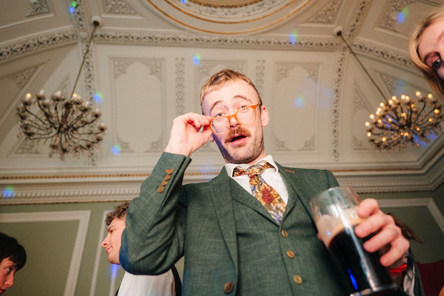 Wedding guests in formal attire enjoying animated moments during indoor celebration. Stephens green club dublin Wedding photographer