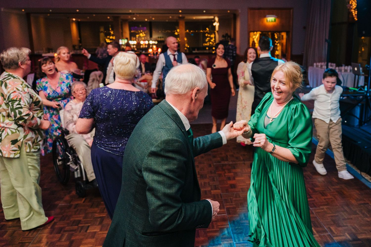Wedding guests dancing in formal attire on a brick-paved dance floor.  Wedding PHOTOGRAPHER Trim Castle  Wedding PHOTOGRAPHER Trim Castle