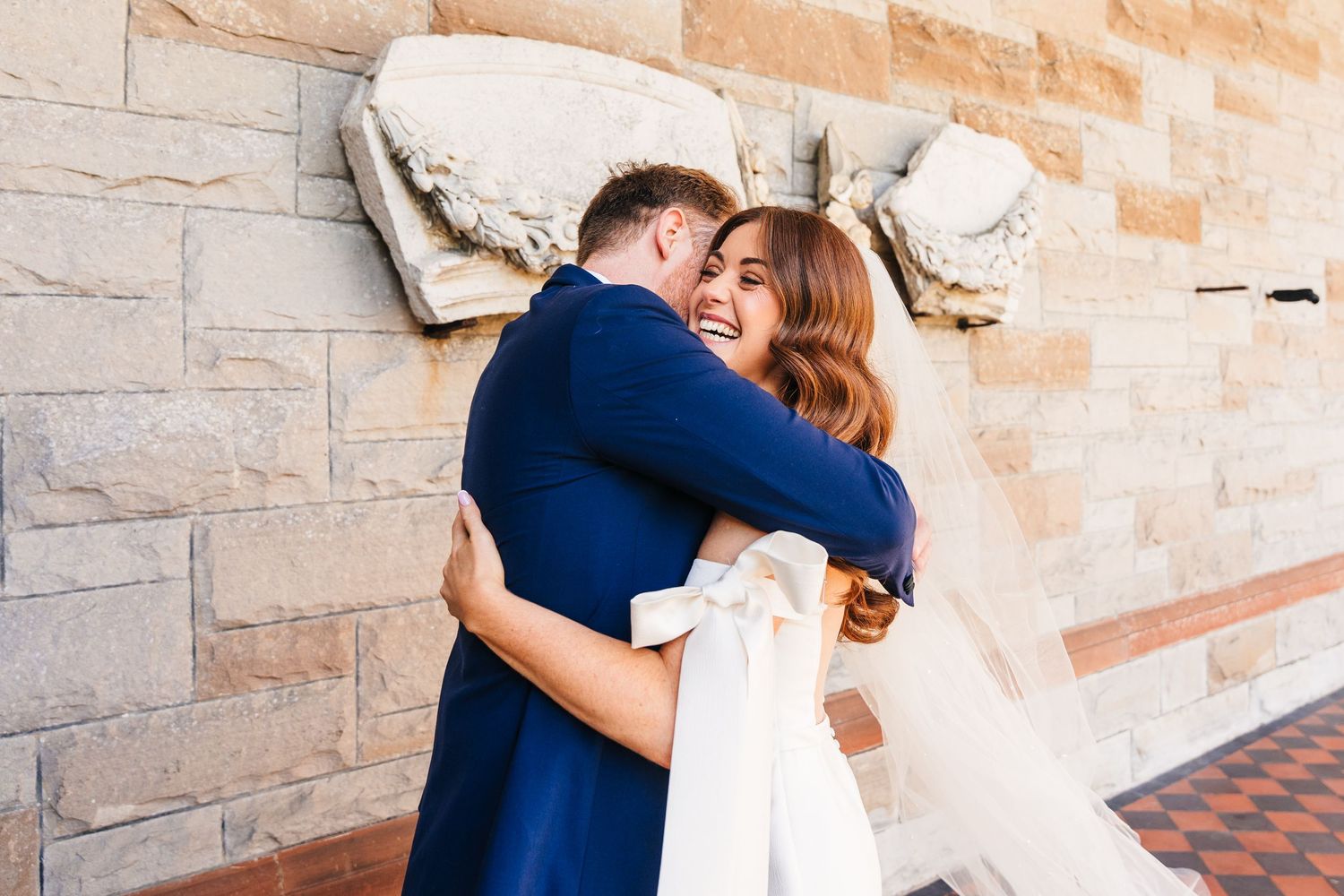 Castle Leslie Wedding Photographer Dublin Intimate embrace between newlyweds against a stone wall backdrop.
