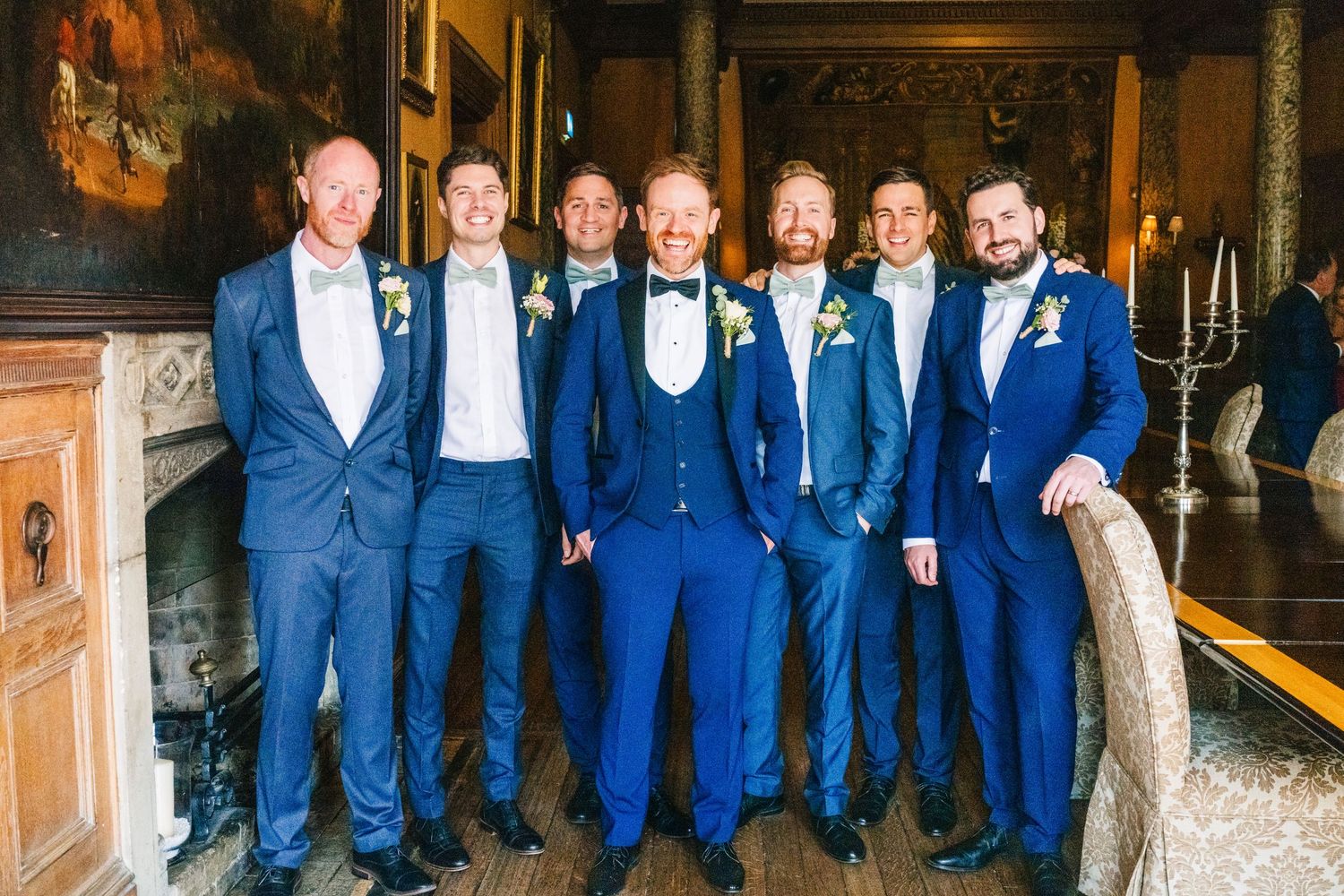 Castle Leslie Wedding Photographer Dublin Wedding party in coordinated navy blue suits posing together at an elegant indoor venue.
