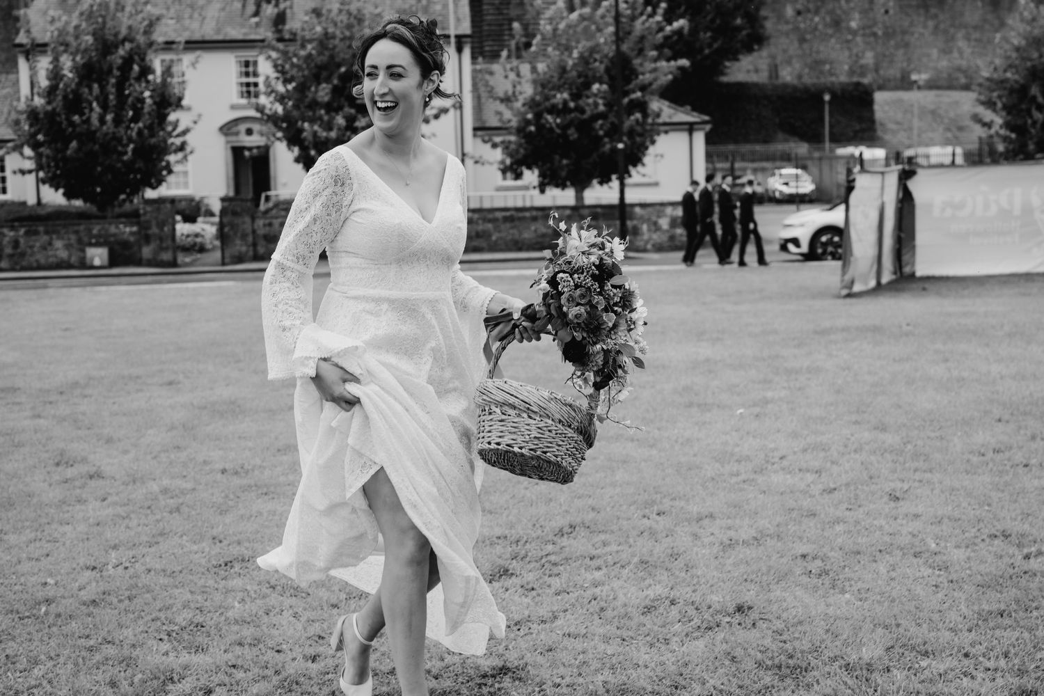 Bride in white dress walking outdoors in black and white photography. Wedding Photography Trim Castle Ireland