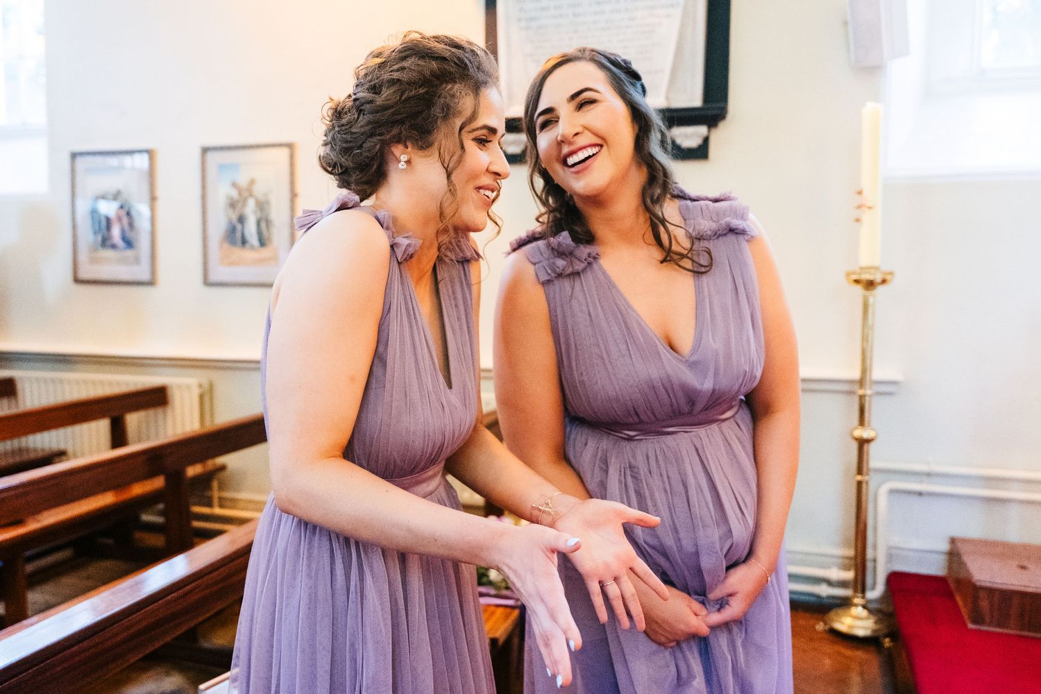 Millhouse slane wedding photographer dublin Bridesmaids in lavender dresses sharing joyful moments together in a bright indoor setting.