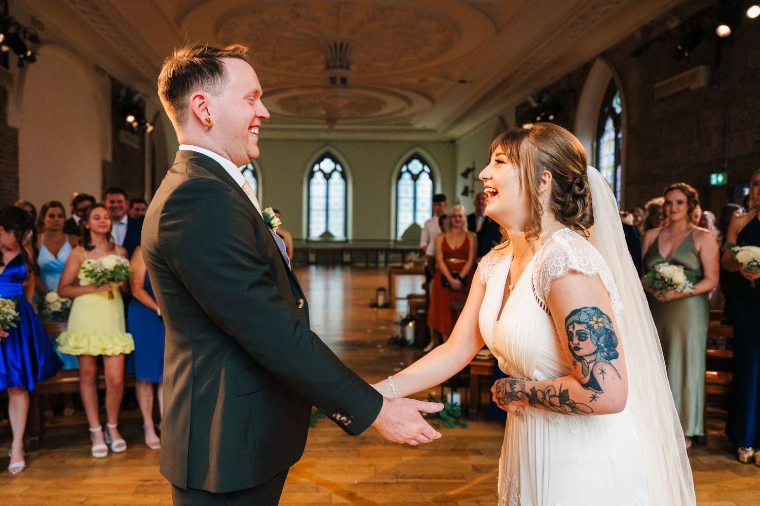 A couple sharing their first dance in a beautiful historic venue with arched windows. PHOTOGRAPHER Dublin Ireland Wedding