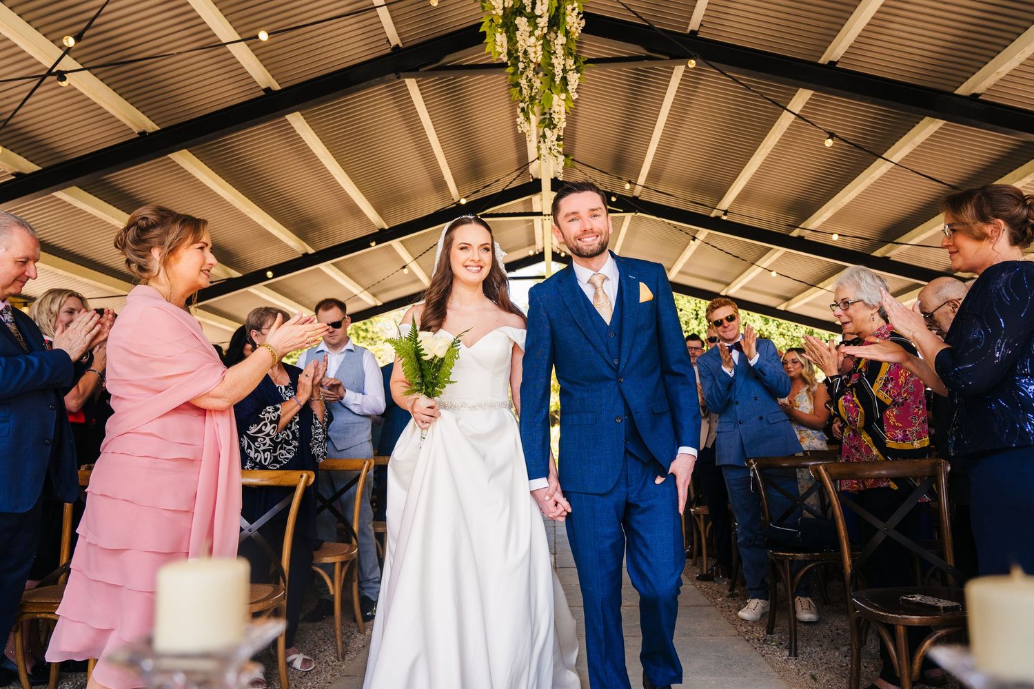 Poulaphouca Wedding photographer wicklow  Wedding celebration under covered venue with guests cheering for newlyweds.