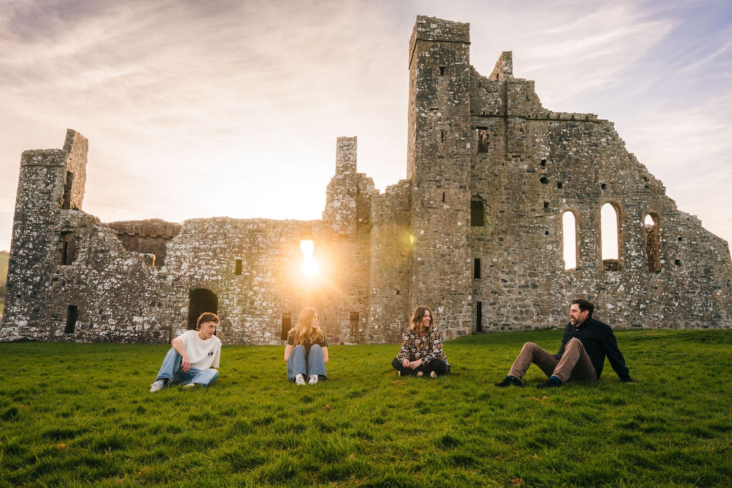 Beautiful engagement photos captured at historic castle ruins during golden hour lighting. Photographer Ireland dublin