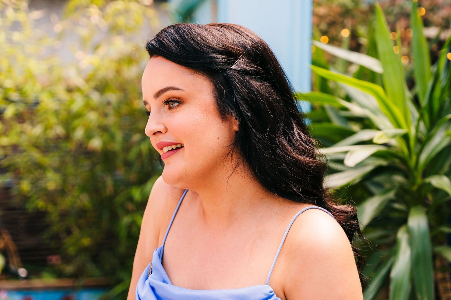 Someone in a blue top smiles against a lush garden background. House Dublin Wedding Photographer