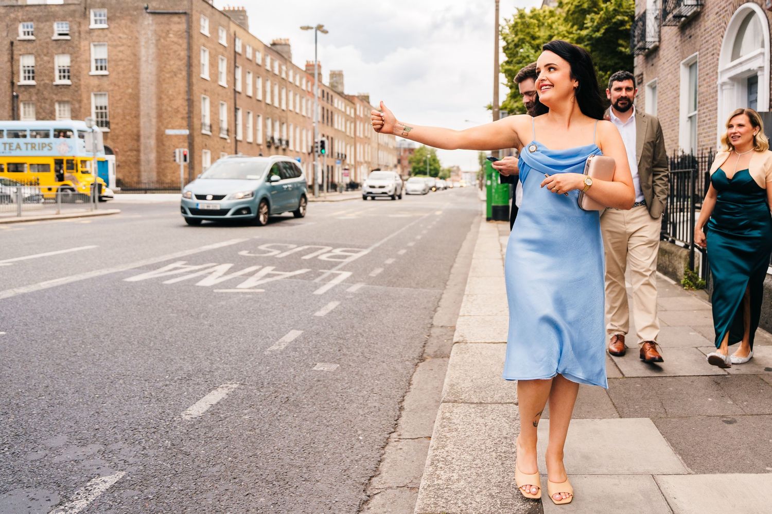 Wedding party members strolling down an urban street lined with historic brick buildings. House Dublin Wedding Photographer