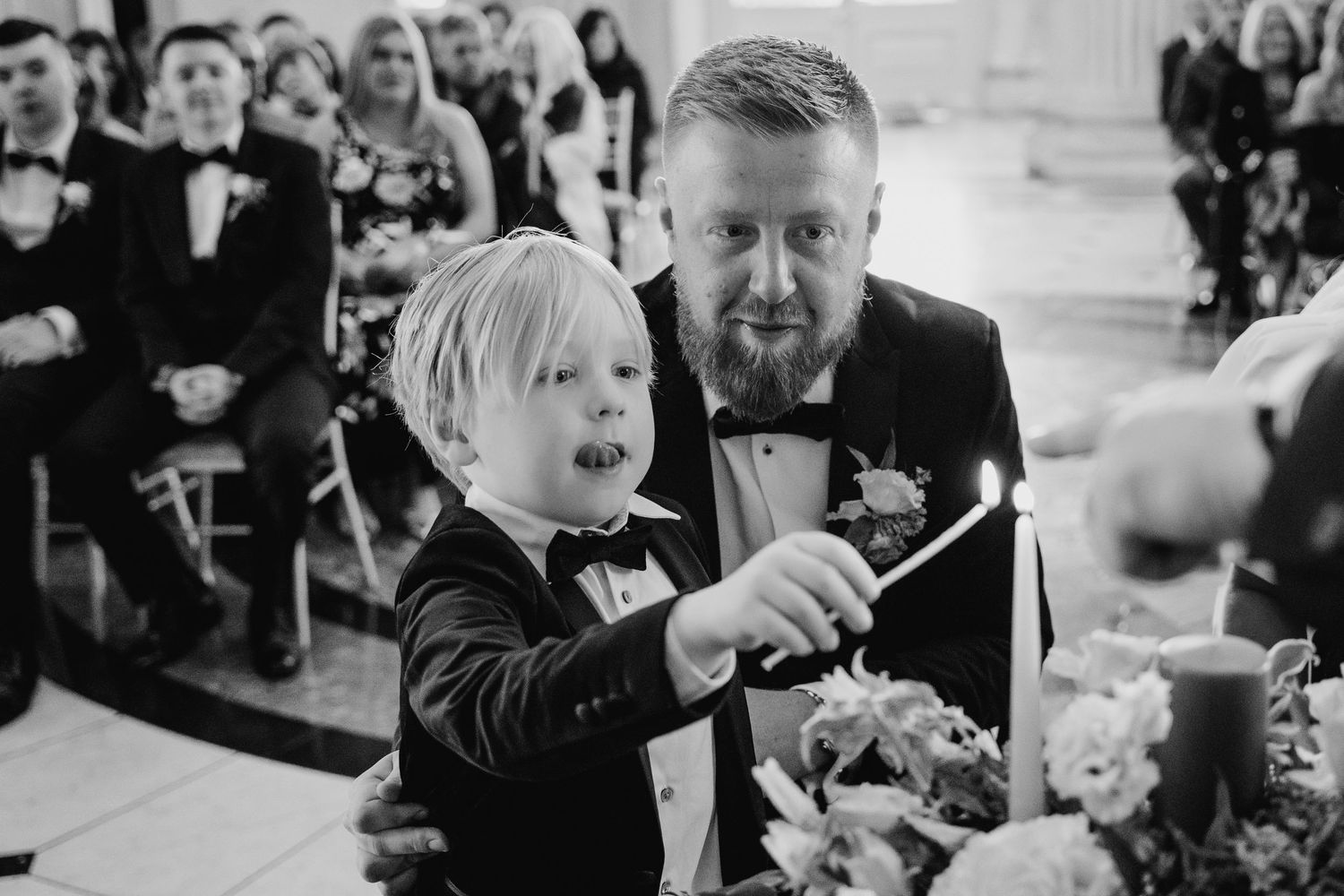 A candid black and white moment of a young child and a person in a suit reacting during a formal celebration. City Hall Dublin Photographer