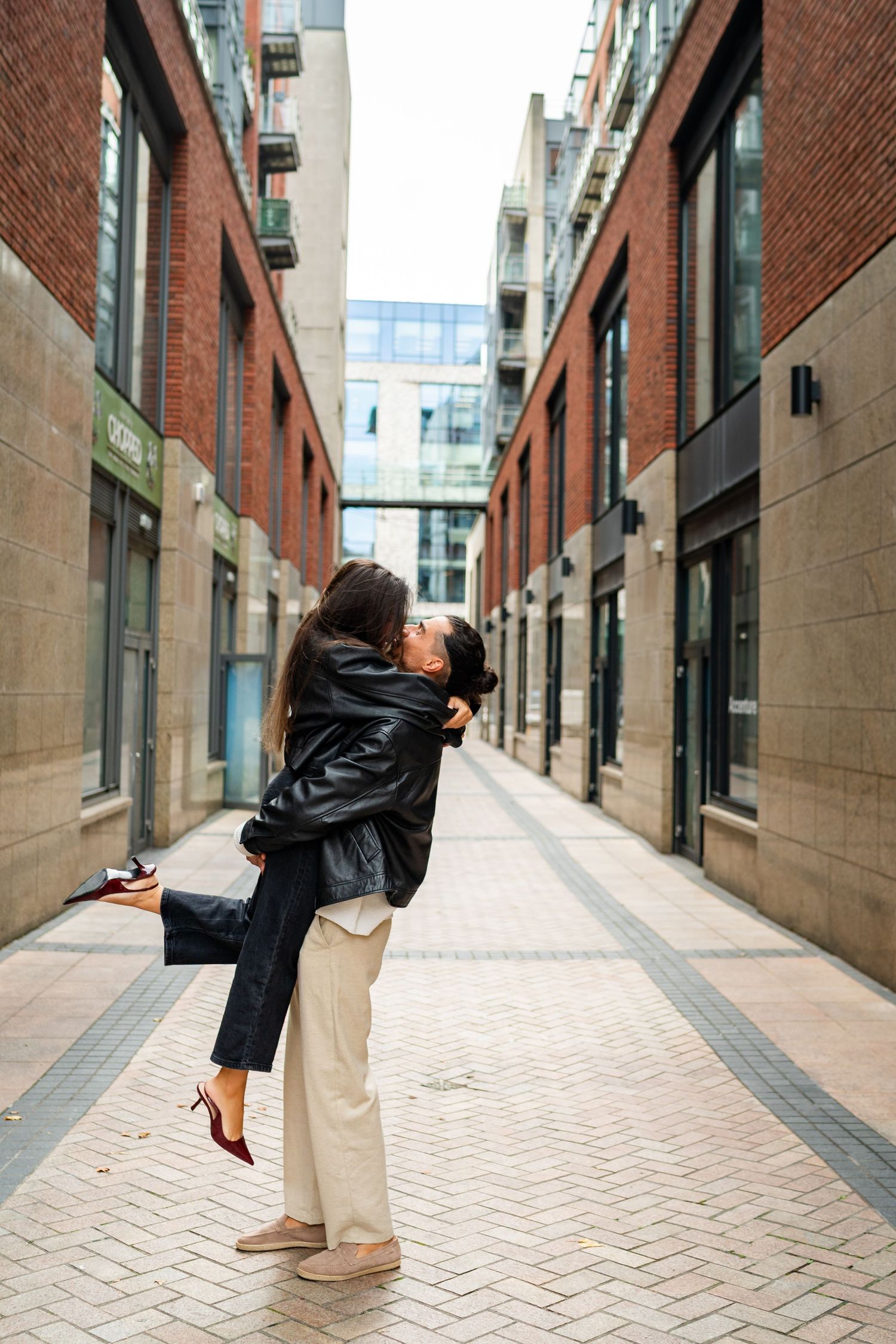 Couple dancing together on a sunlit brick-paved urban pathway in casual attire. Couple's Photoshoot PHOTOGRAPHER Dublin