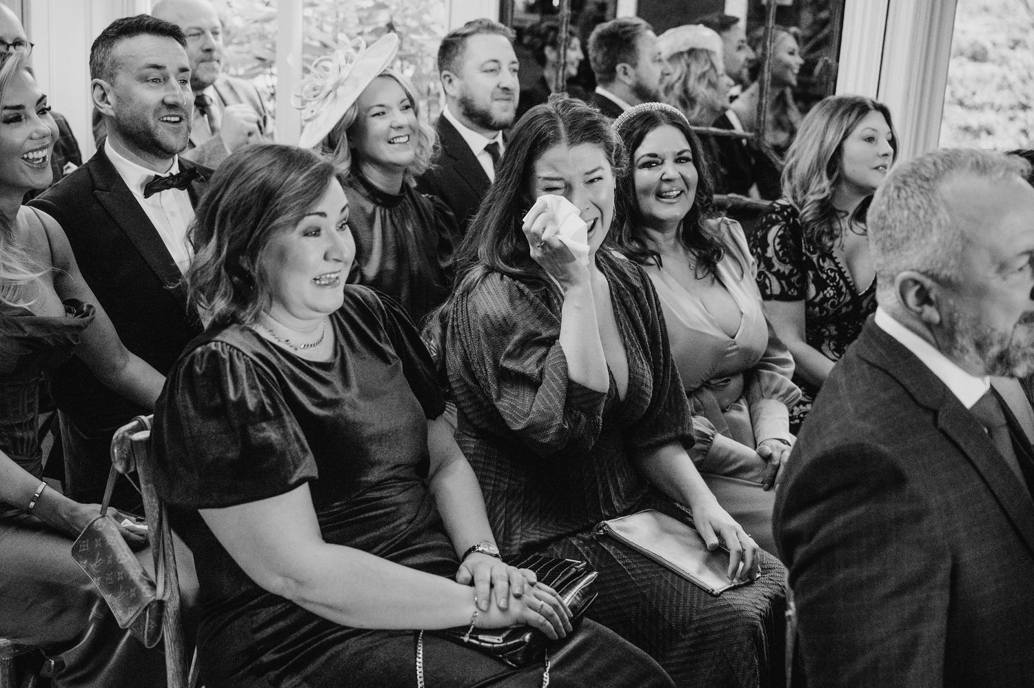 Wedding guests react emotionally during ceremony in black and white photograph.  Virginia Park Lodge Wedding Photographer Cavan Dublin Irela