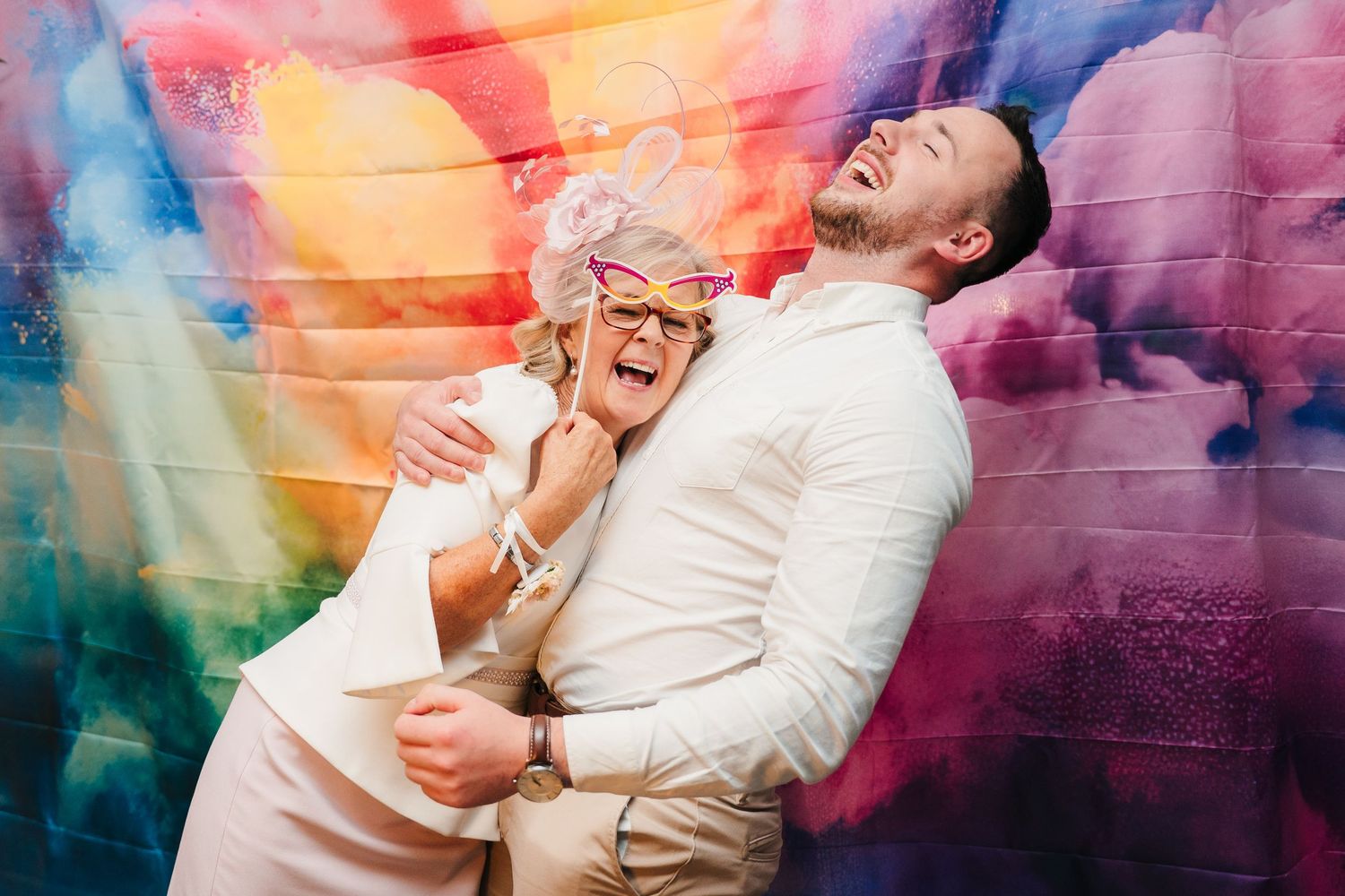 A couple shares a joyful moment together amid colorful smoke effects and vibrant lighting. wedding photographer dublin pricing meath