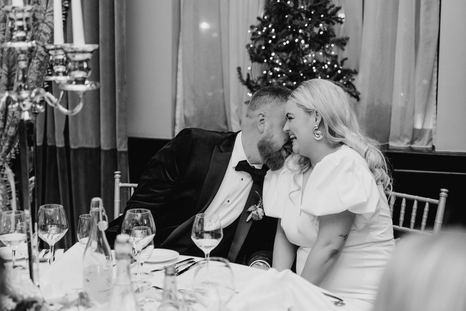 Black and white wedding reception photo with Christmas trees and table settings visible. Wedding photographer dublin