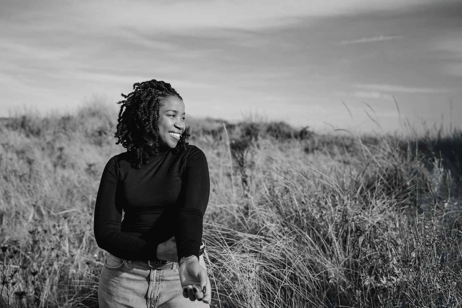 Black and white portrait series showing expressive movements in tall grass. Dublin professional headshots photographer