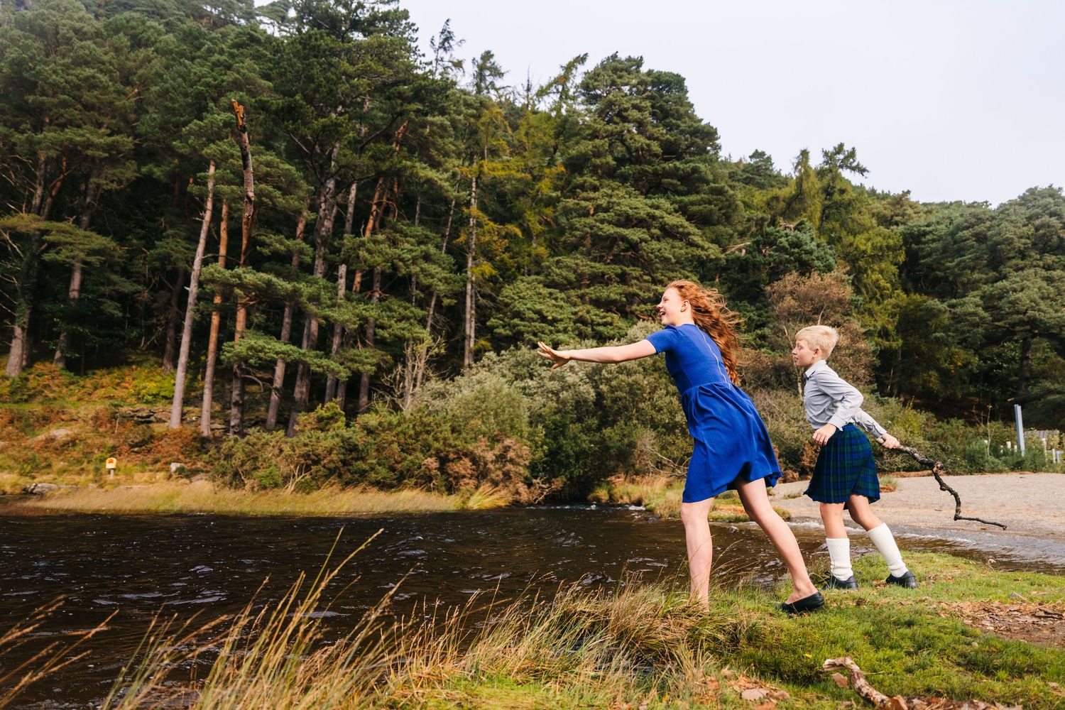 Multiple groups pose along a scenic lakeside trail surrounded by pine trees and natural landscapes.Family photogrAPHER DUBLIN