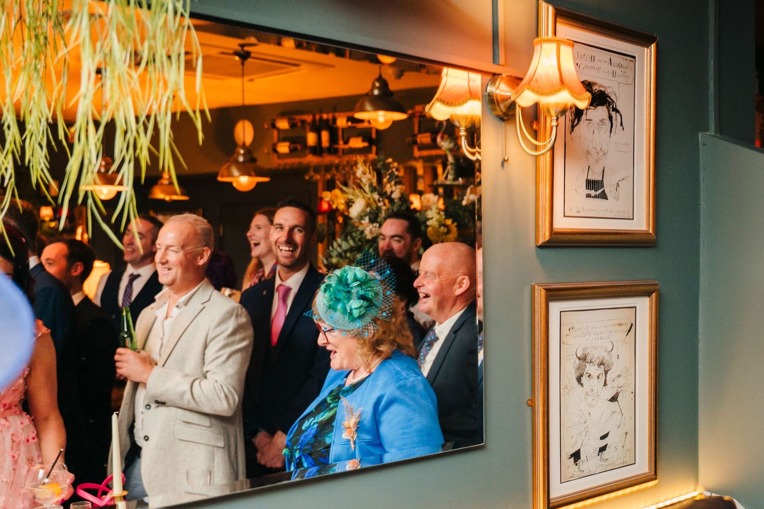Wedding guests gathered under hanging decorations at an elegant indoor venue.