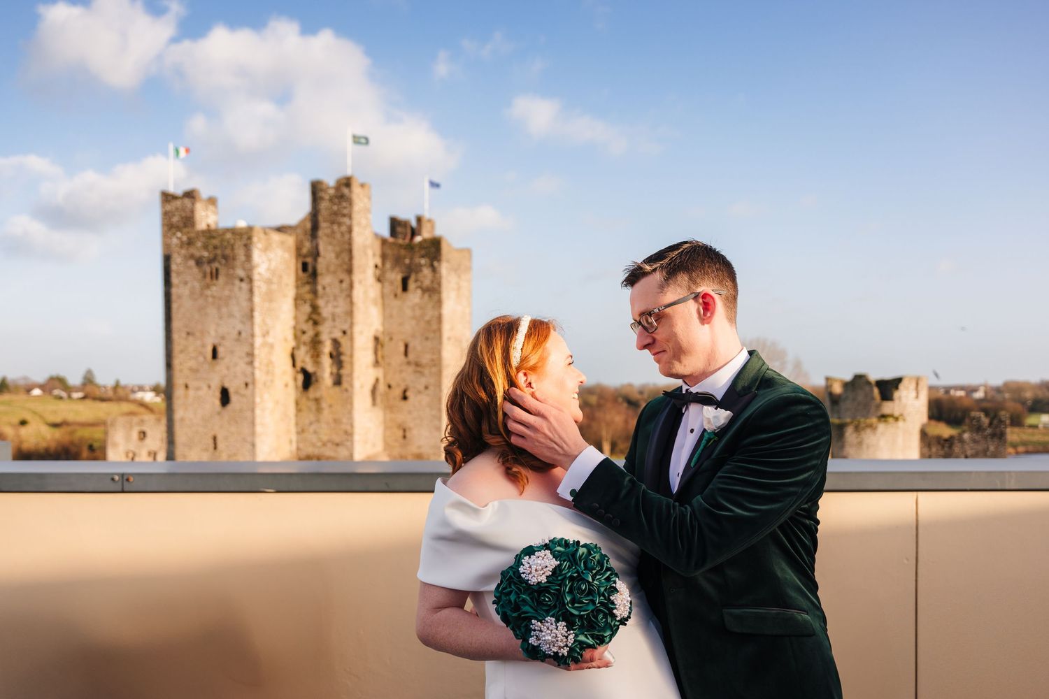 Castle backdrop wedding photos captured on a rooftop terrace under blue skies.  Wedding PHOTOGRAPHER Trim Castle
