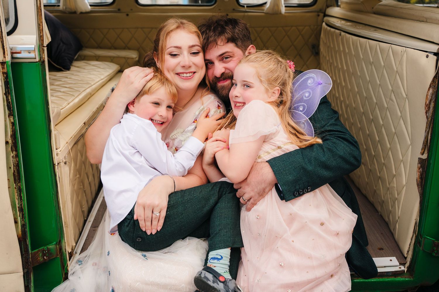 A family shares a tender moment while cuddled together in the back of a vintage van. . Village Barn Tyrrellspass wedding photographer Irelan
