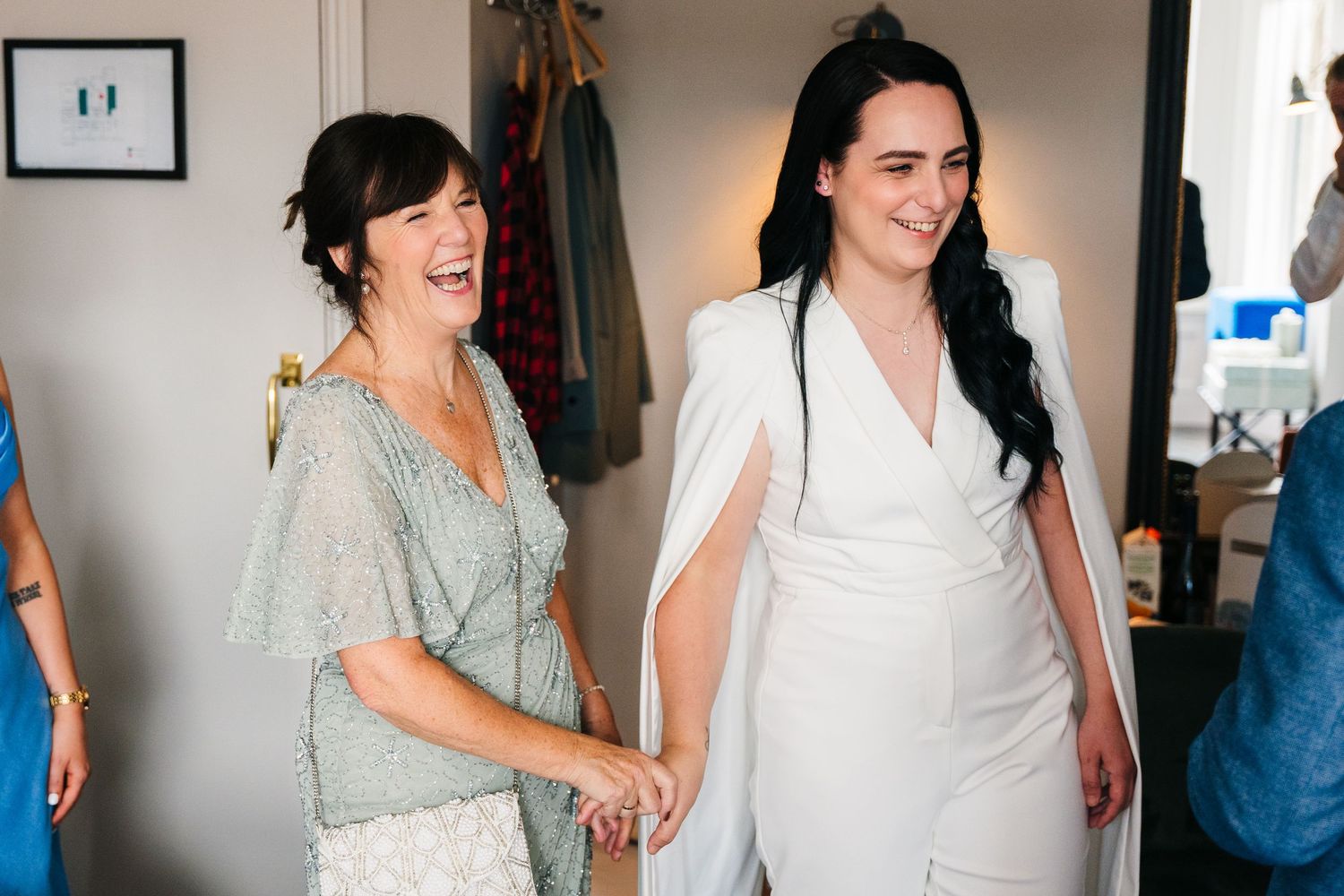 Two people sharing a joyful moment while getting ready in formal attire. House Dublin Wedding Photographer
