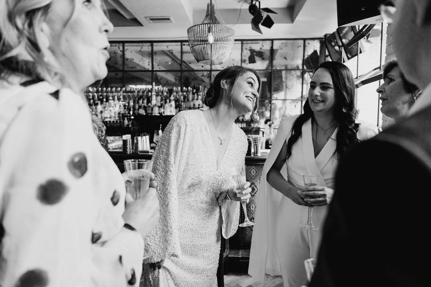 A candid black and white photo series showing joyful moments and laughter at an outdoor garden party. House Dublin Wedding Photographer
