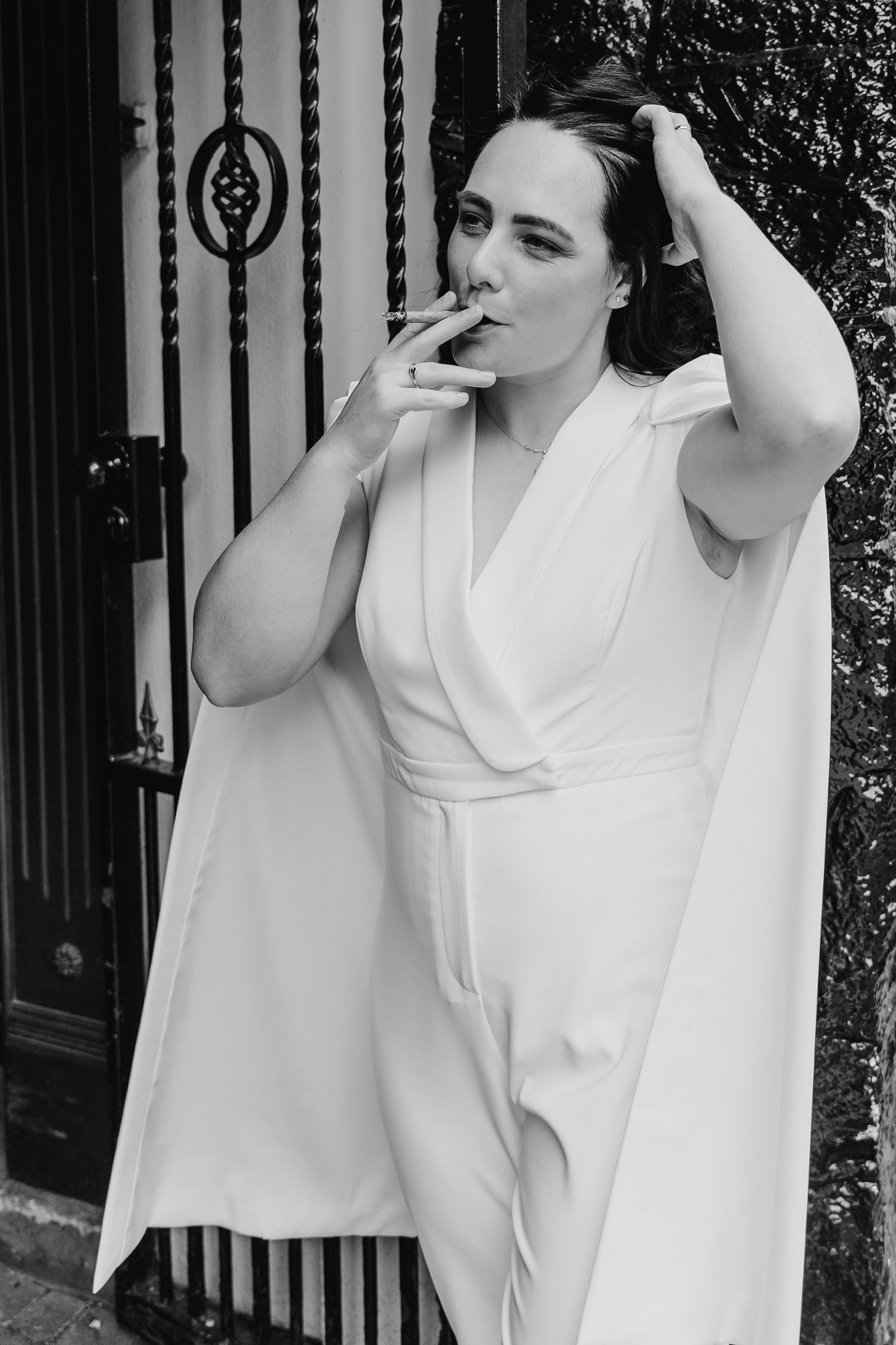Artistic black and white portrait series showing dramatic poses against a dark fence background. House Dublin Wedding Photographer