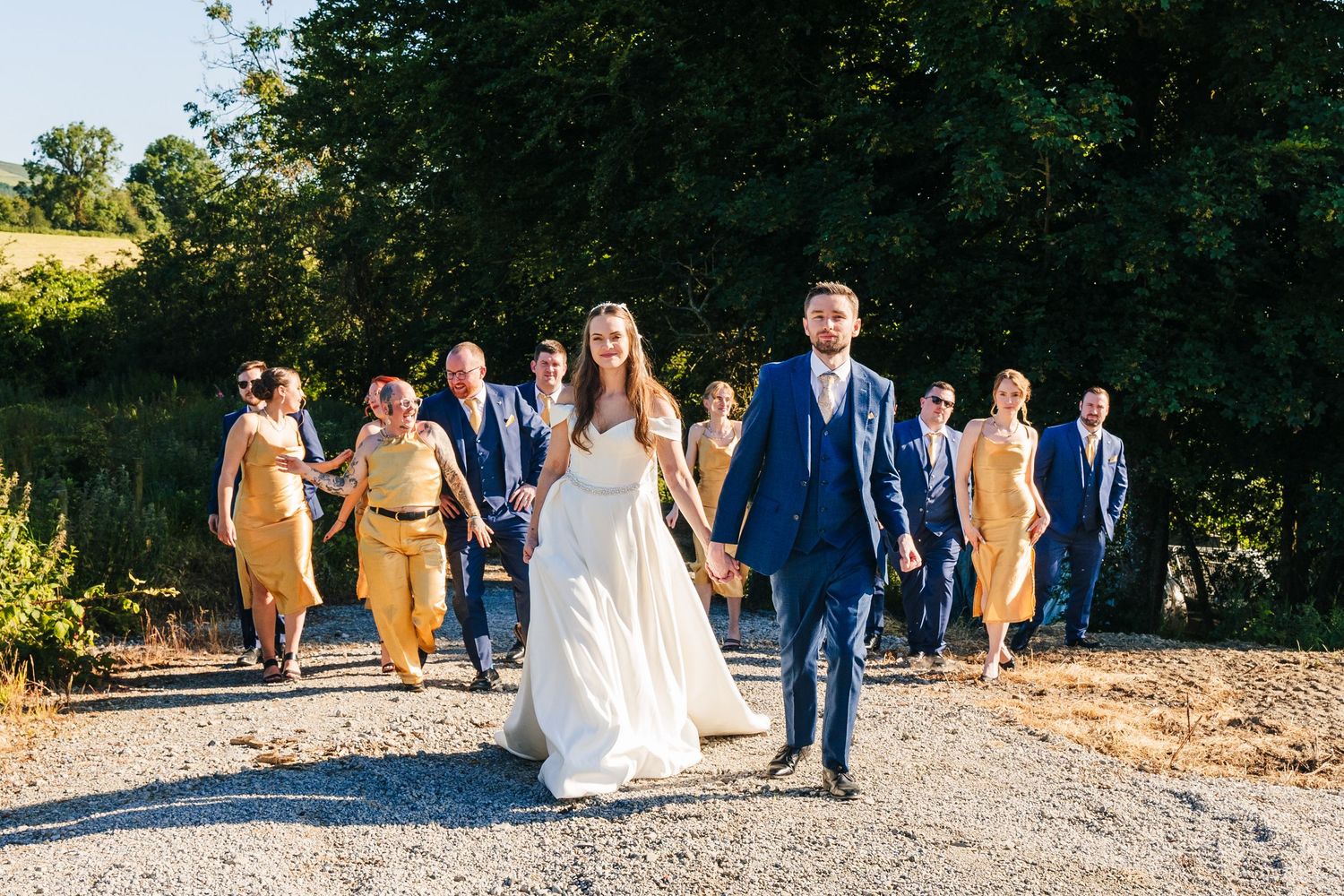 Poulaphouca Wedding photographer wicklow  Wedding party walking down path with bride and groom leading.