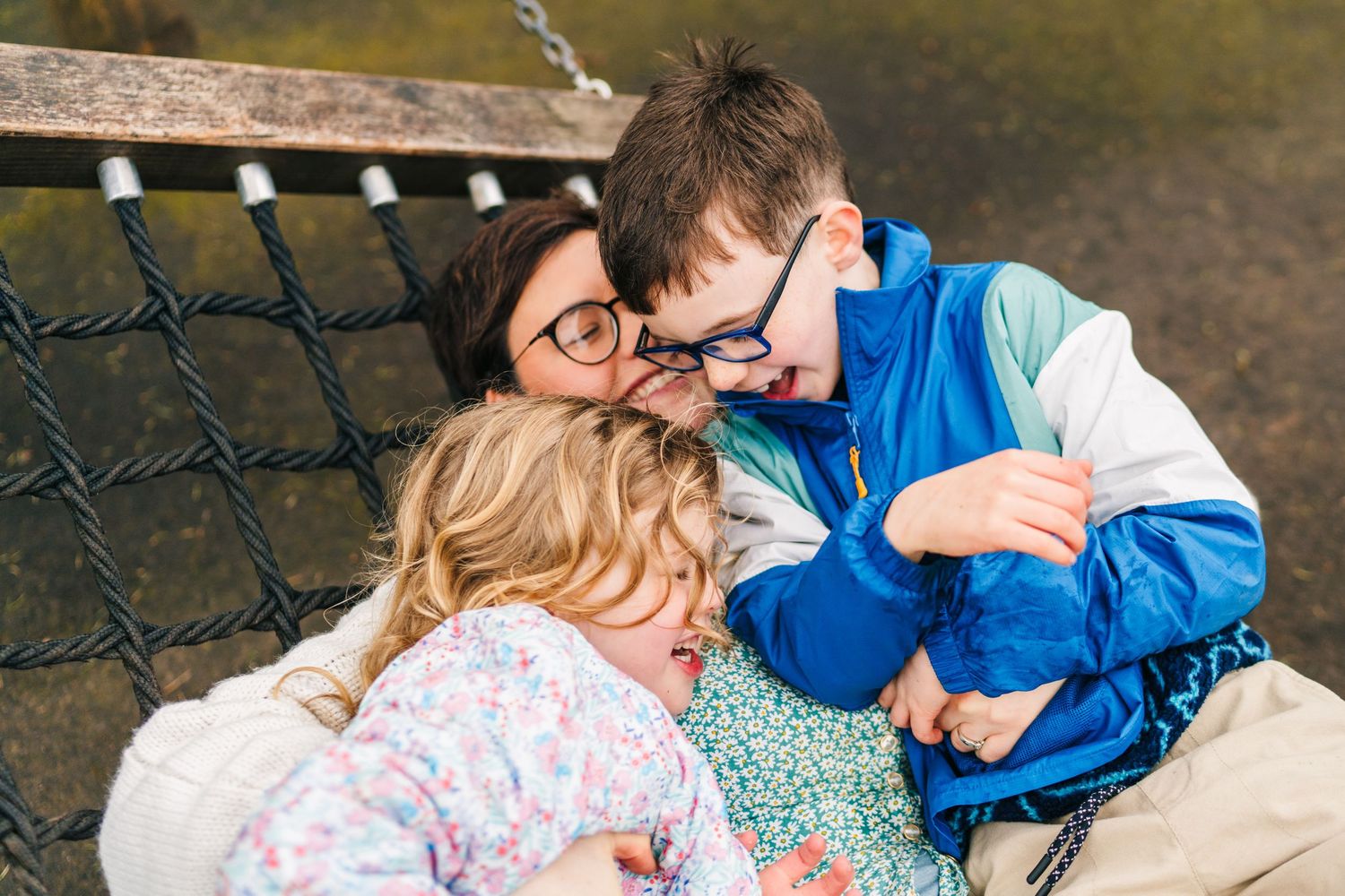 Family photographer Dublin Ireland  A tender family moment shared on a bench swing in the park.
