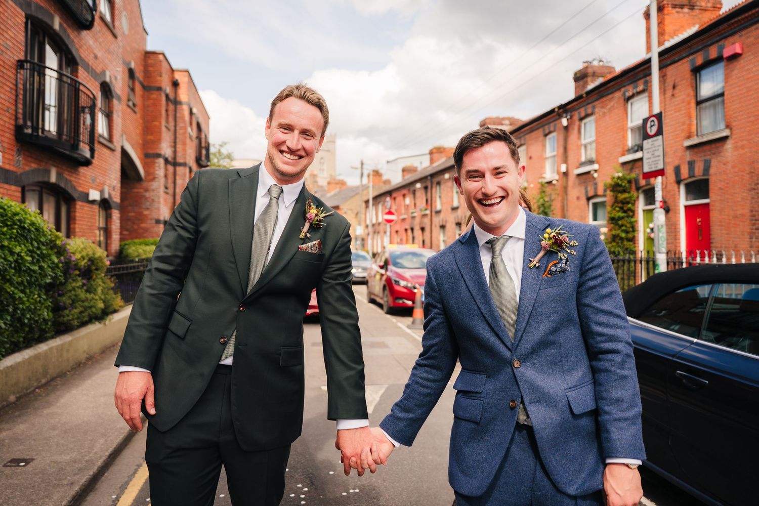 Wedding party members having fun and posing on a street with traditional red brick buildings. Same sex wedding PHOTOGRAPHER Dublin
