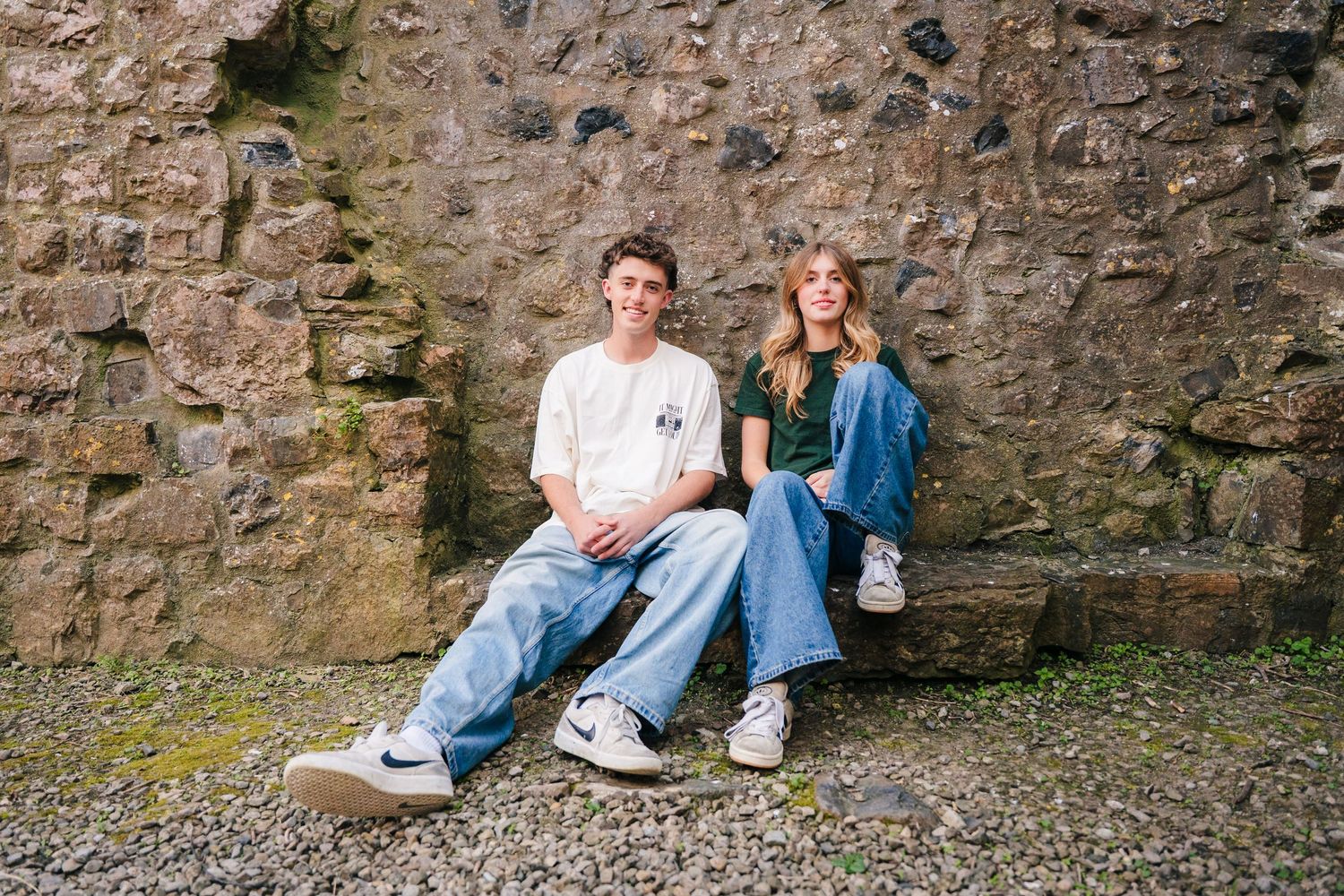 Friends relaxing along an old stone wall during an outdoor photo session. Photographer Ireland dublin
