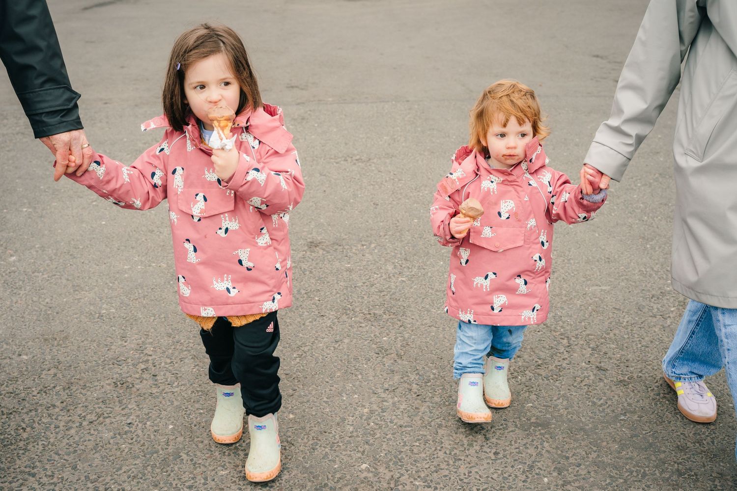 Two children in matching pink penguin coats walk hand-in-hand with adults. PHOTOGRAPHER Dublin