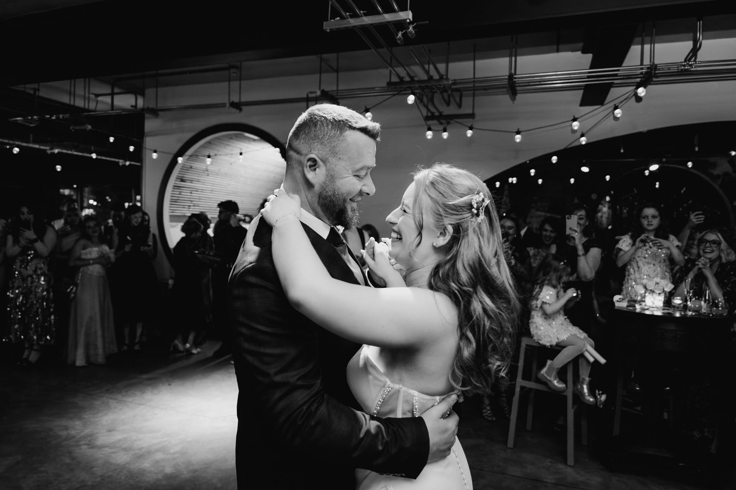 Wedding reception dance floor with string lights overhead and guests dancing in silhouette. Dublin wedding photogrAPher