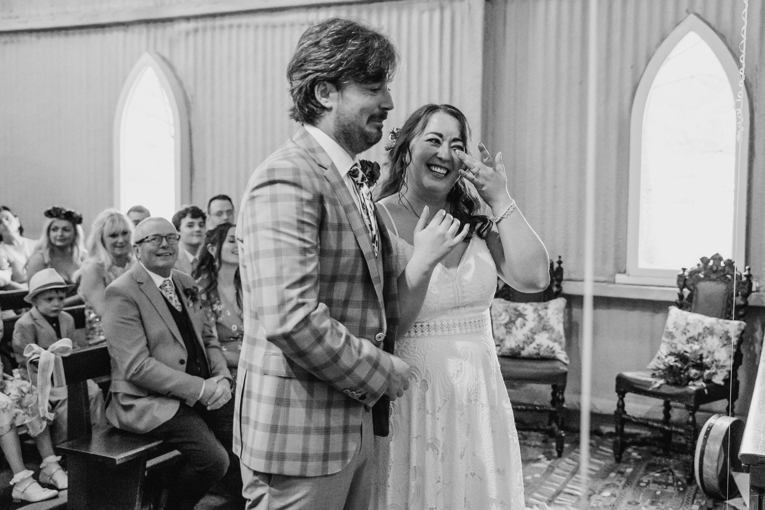 Black and white photo of a couple sharing a laugh during their wedding ceremony. Wedding photographer Dublin