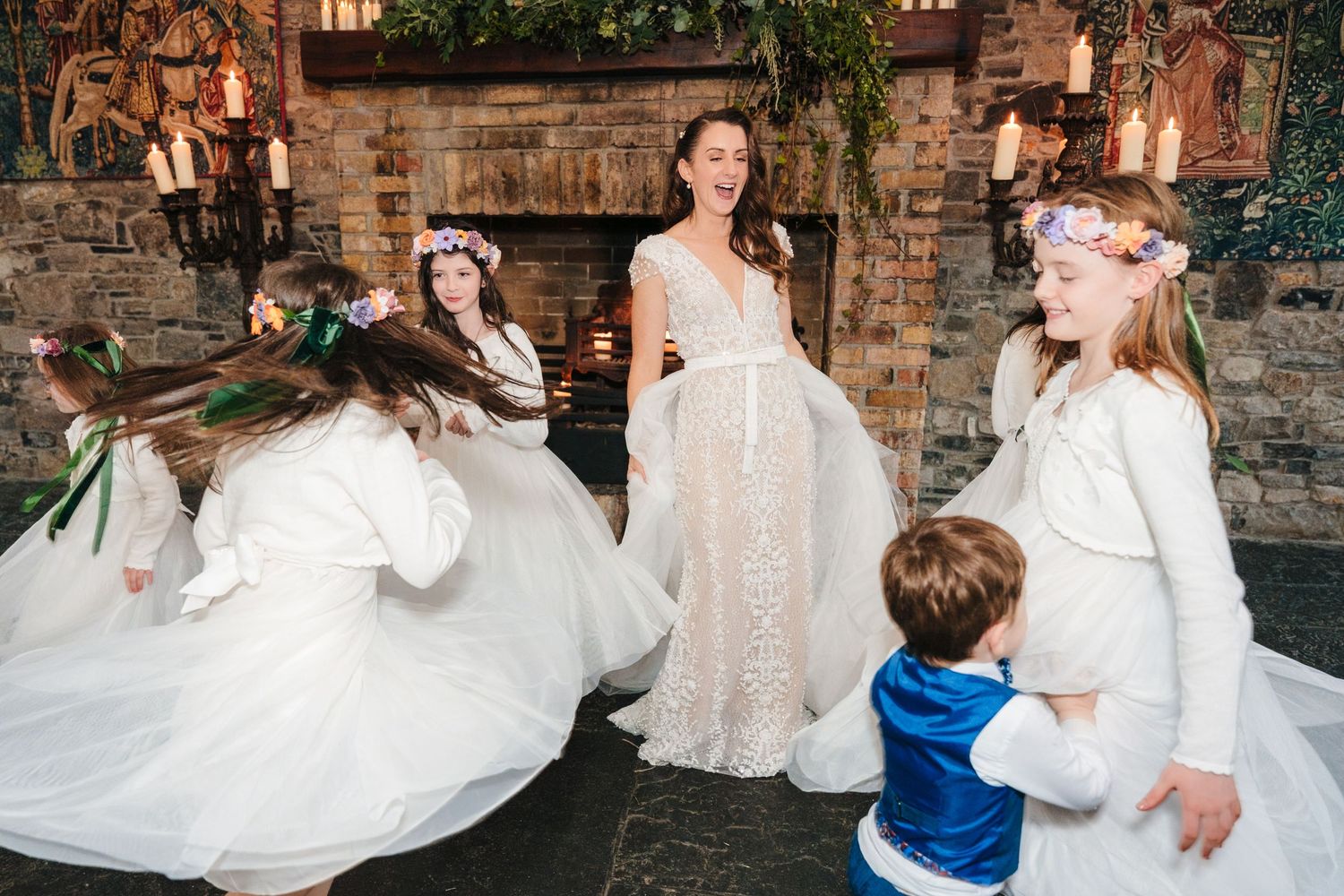 Wedding party dancing and celebrating in a rustic brick-walled venue.