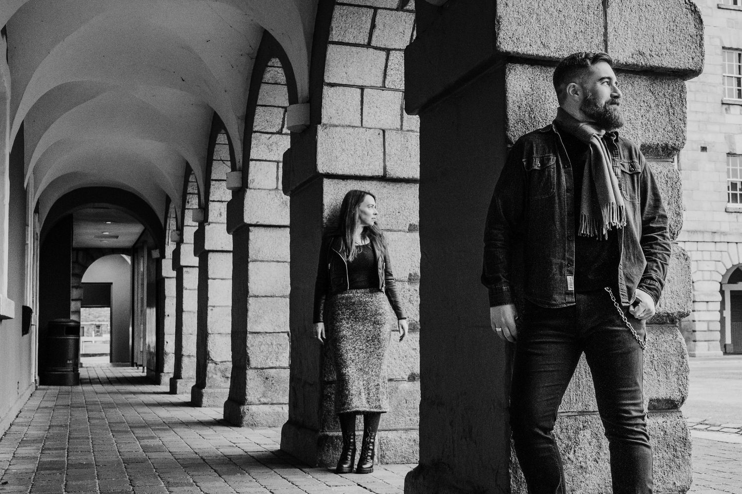 A dramatic black and white photo of two people posing in an arched colonnade hallway. PHOTOGRAPHER Dublin ireland