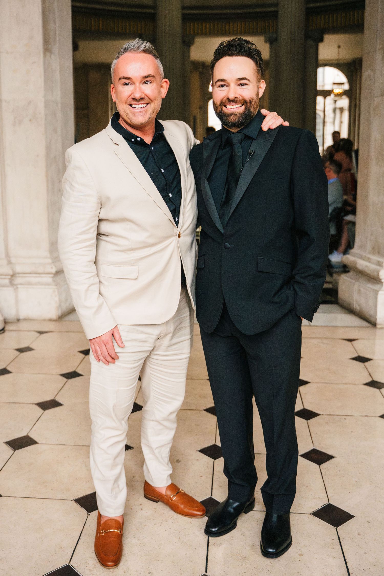 Two people in contrasting black and white formal attire pose together on a checkered floor.  city hall dublin wedding photos