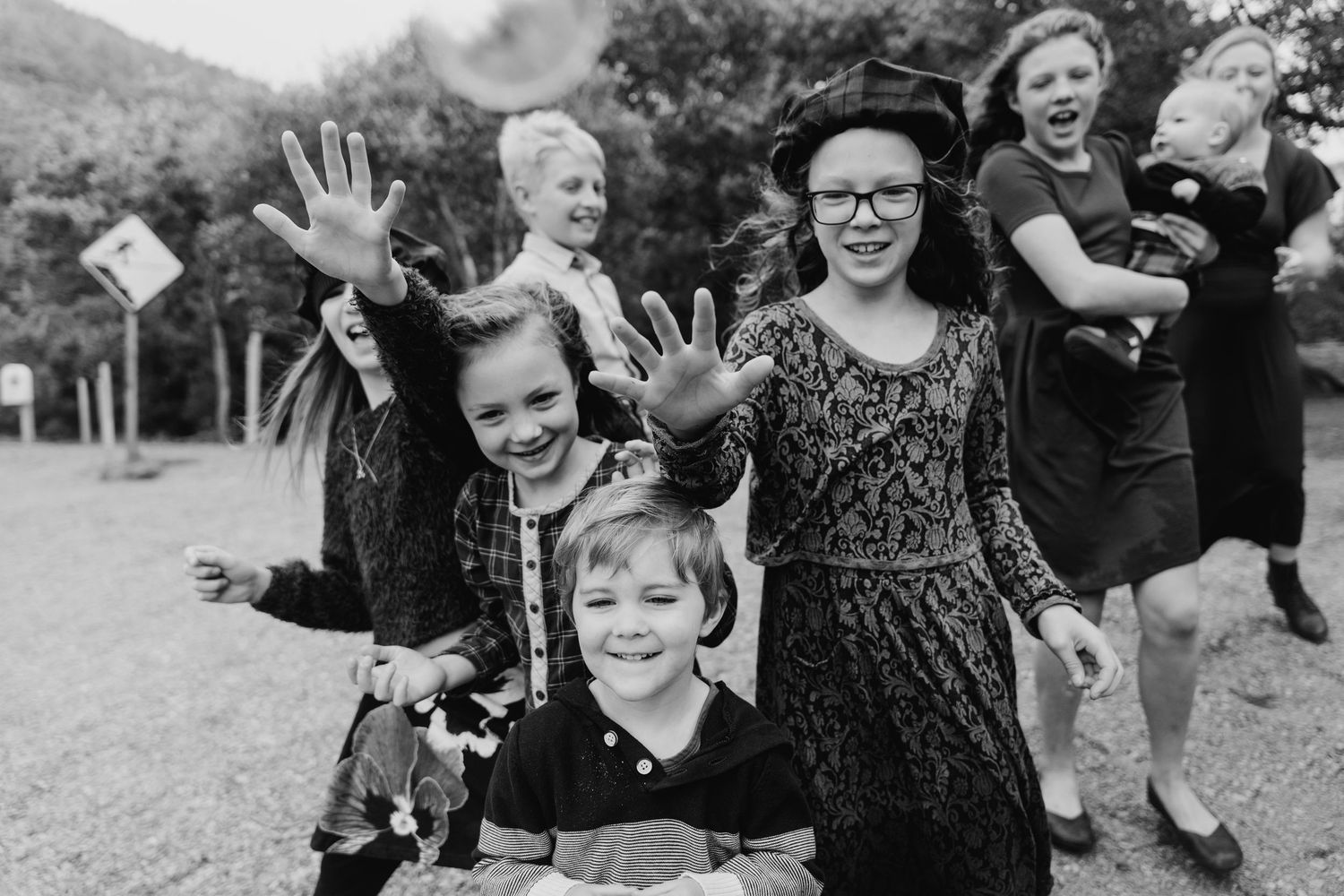 Black and white photo of joyful family members laughing and playing together outdoors.Family photogrAPHER DUBLIN