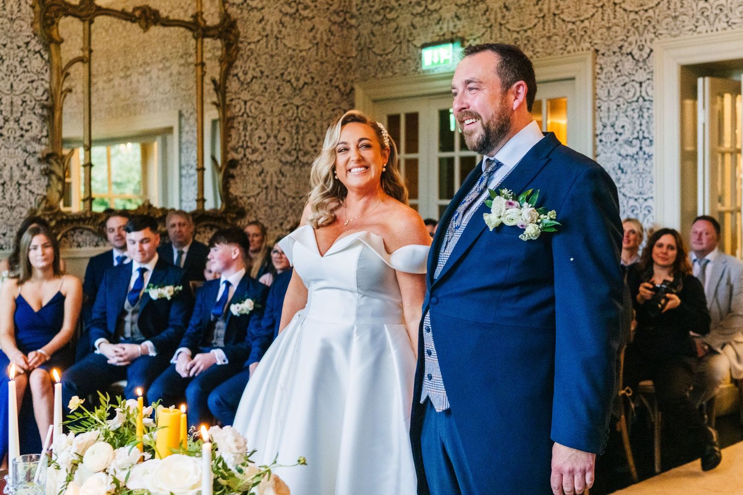 Wedding guests share joyful laughter and reactions during a reception celebration in an elegant venue.  Virginia Park Lodge Wedding Photogra