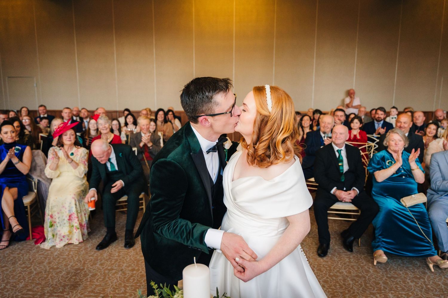 Wedding reception venue with amber lighting and crowd of guests watching dance floor.  Wedding PHOTOGRAPHER Trim Castle