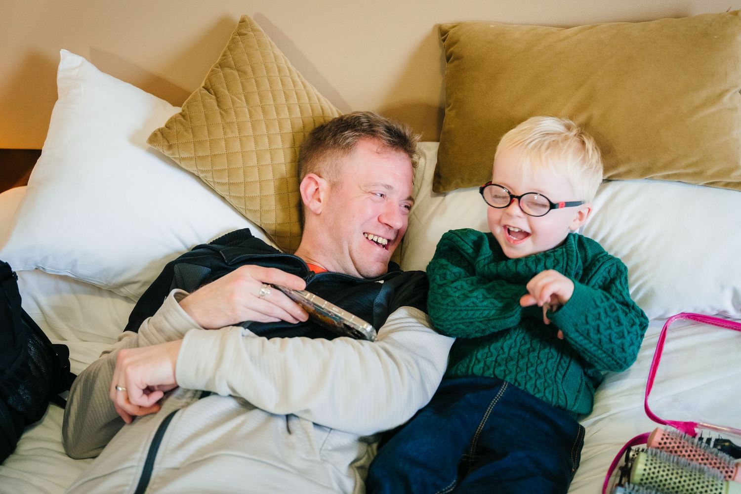 Four sequential photos showing joyful bonding moments between two people cuddling and laughing together on a couch.  Wedding PHOTOGRAPHER Tr