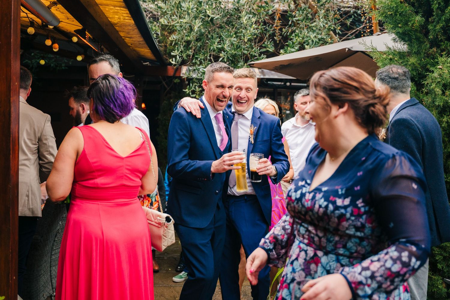 Guests dance and celebrate together at an outdoor reception with trees and greenery in the background. Marco Pierre Dublin Wedding Photograp