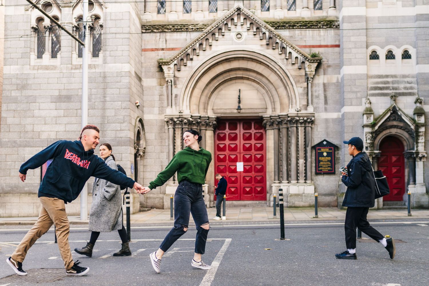 Group performing dynamic movements in front of ornate stone church architecture. PHOTOGRAPHER Dublin Ireland