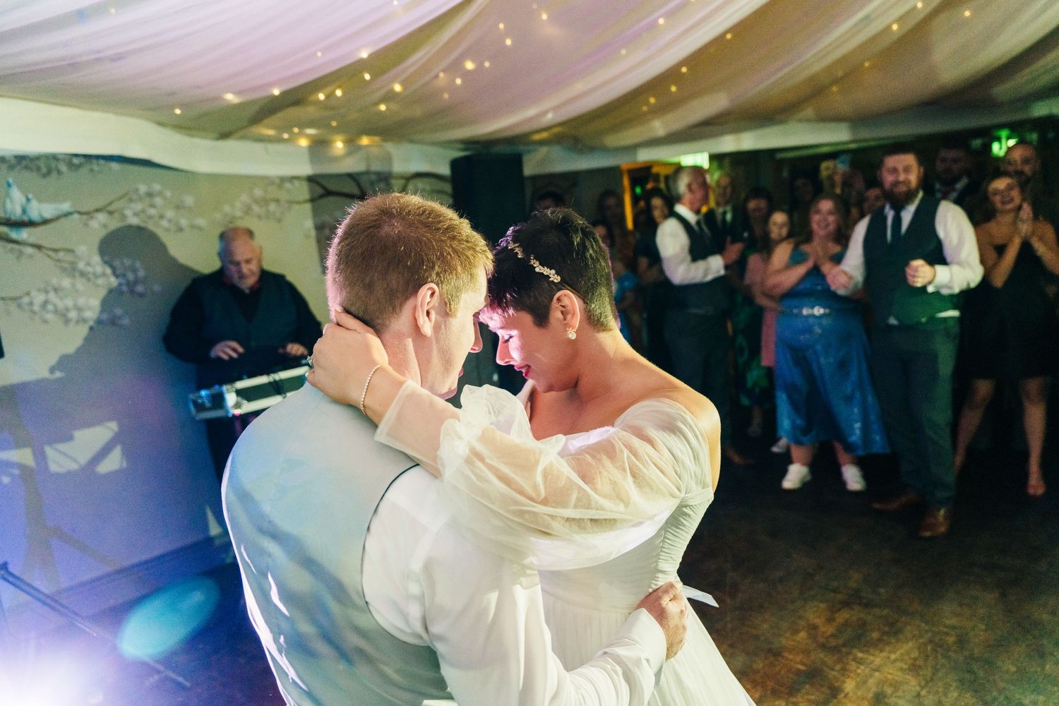 Millhouse slane wedding photographer dublinCouple shares romantic first dance under draped ceiling with twinkle lights at wedding reception.