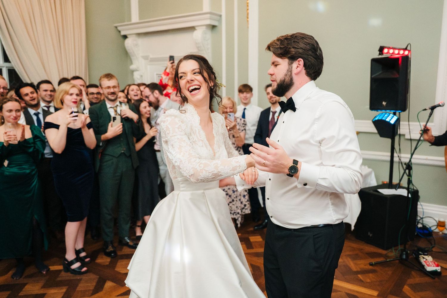 Wedding guests dance and celebrate during a lively reception in an elegant indoor venue.